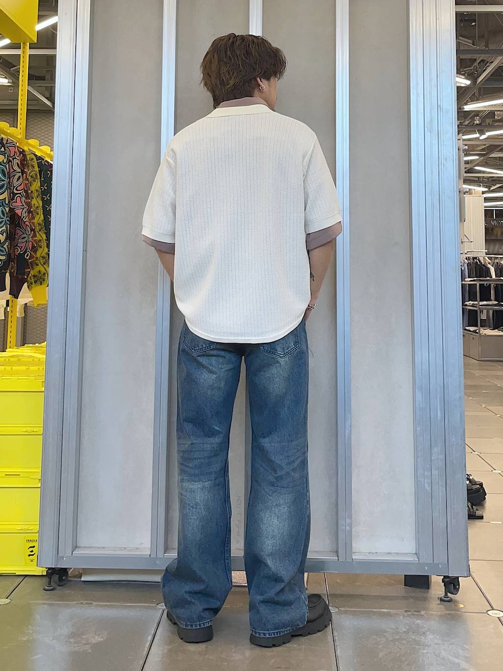 ブラック系のドレスシューズ、ホワイト系のニット/セーター、ブルー系のデニムパンツを着用したメンズの春コーディネートの2枚目の写真
