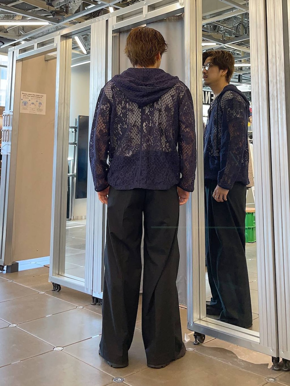 ブラック系のドレスシューズ、ブラック系のスラックス、ブルー系のパーカーを着用したメンズの春コーディネートの2枚目の写真