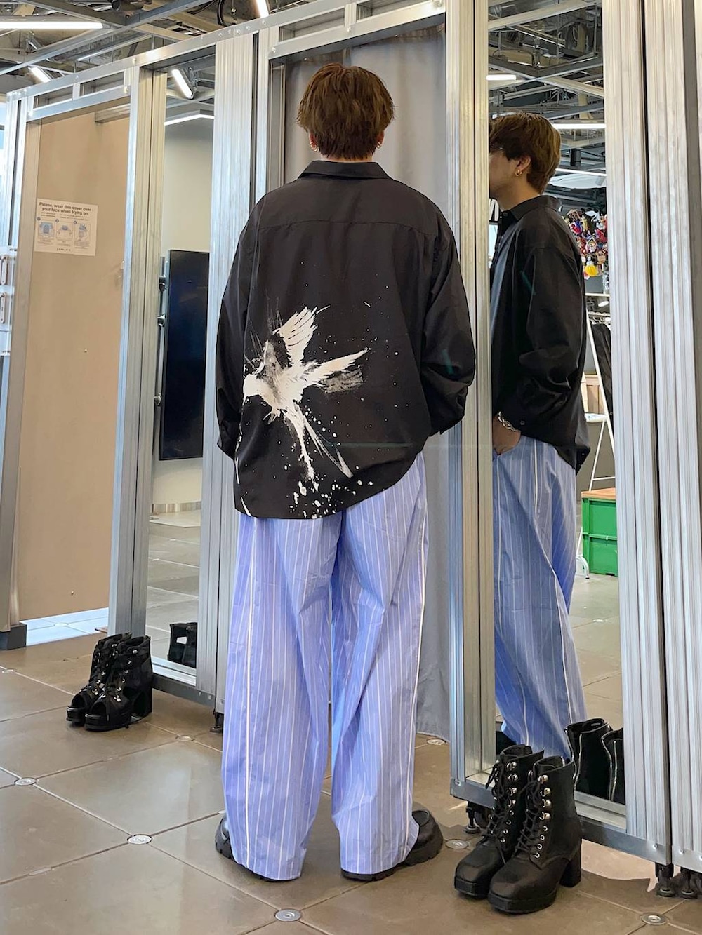 ブラック系のドレスシューズ、ブルー系のスラックス、ブラック系のシャツ/ブラウスを着用したメンズの春コーディネートの2枚目の写真