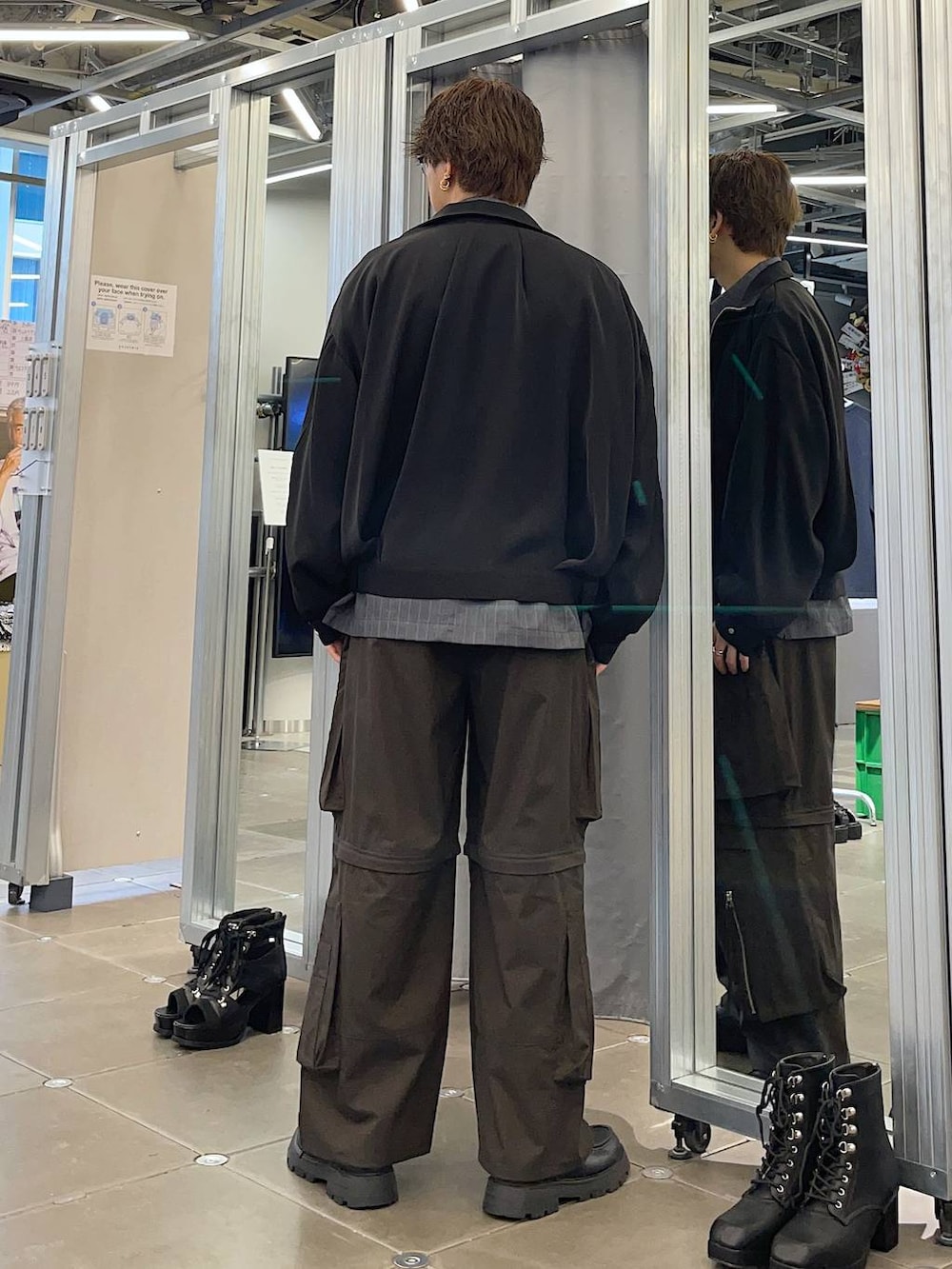 ブラック系のドレスシューズ、ブラック系のブルゾン、ブラウン系のカーゴパンツを着用したメンズの春コーディネートの2枚目の写真