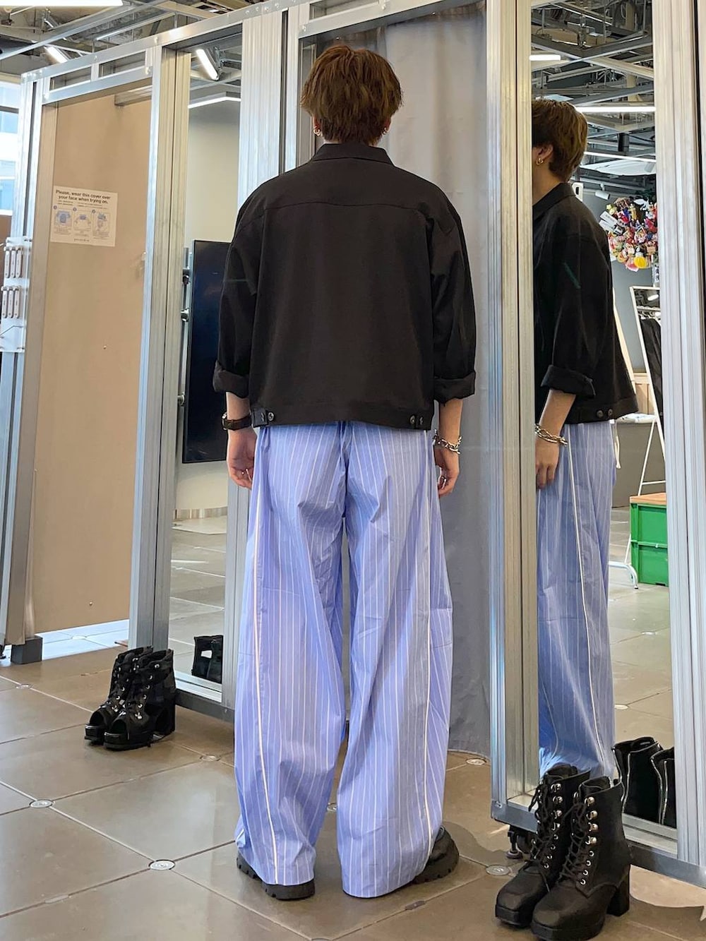 ブラック系のドレスシューズ、ブルー系のスラックス、ブラック系のブルゾンを着用したメンズの春コーディネートの2枚目の写真