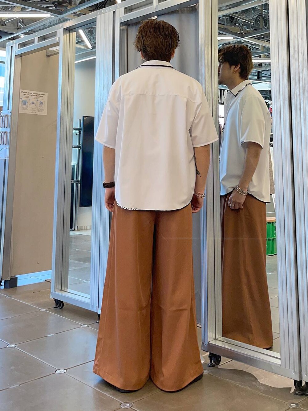 ブラック系のドレスシューズ、オレンジ系のスラックス、ホワイト系のTシャツ/カットソーを着用したメンズの春コーディネートの2枚目の写真