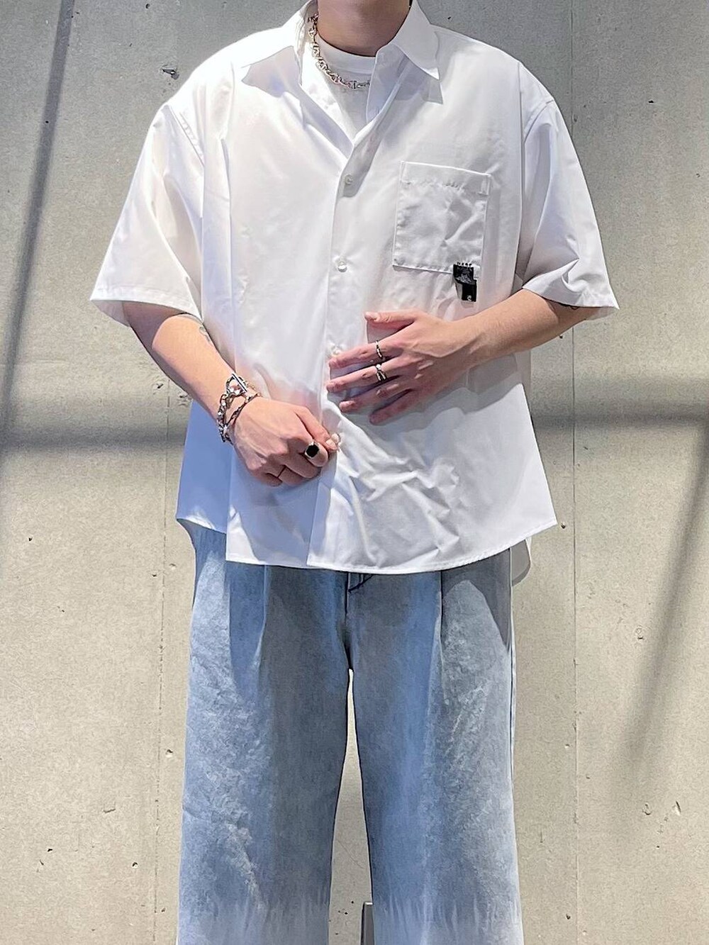 ブラック系のサンダル、ブルー系のデニムパンツ、ホワイト系のシャツ/ブラウスを着用したメンズの春コーディネートの2枚目の写真