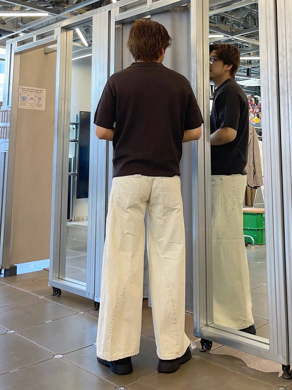 ブラック系のドレスシューズ、ホワイト系のデニムパンツ、ブラウン系のポロシャツを着用したメンズの春コーディネートの2枚目の写真