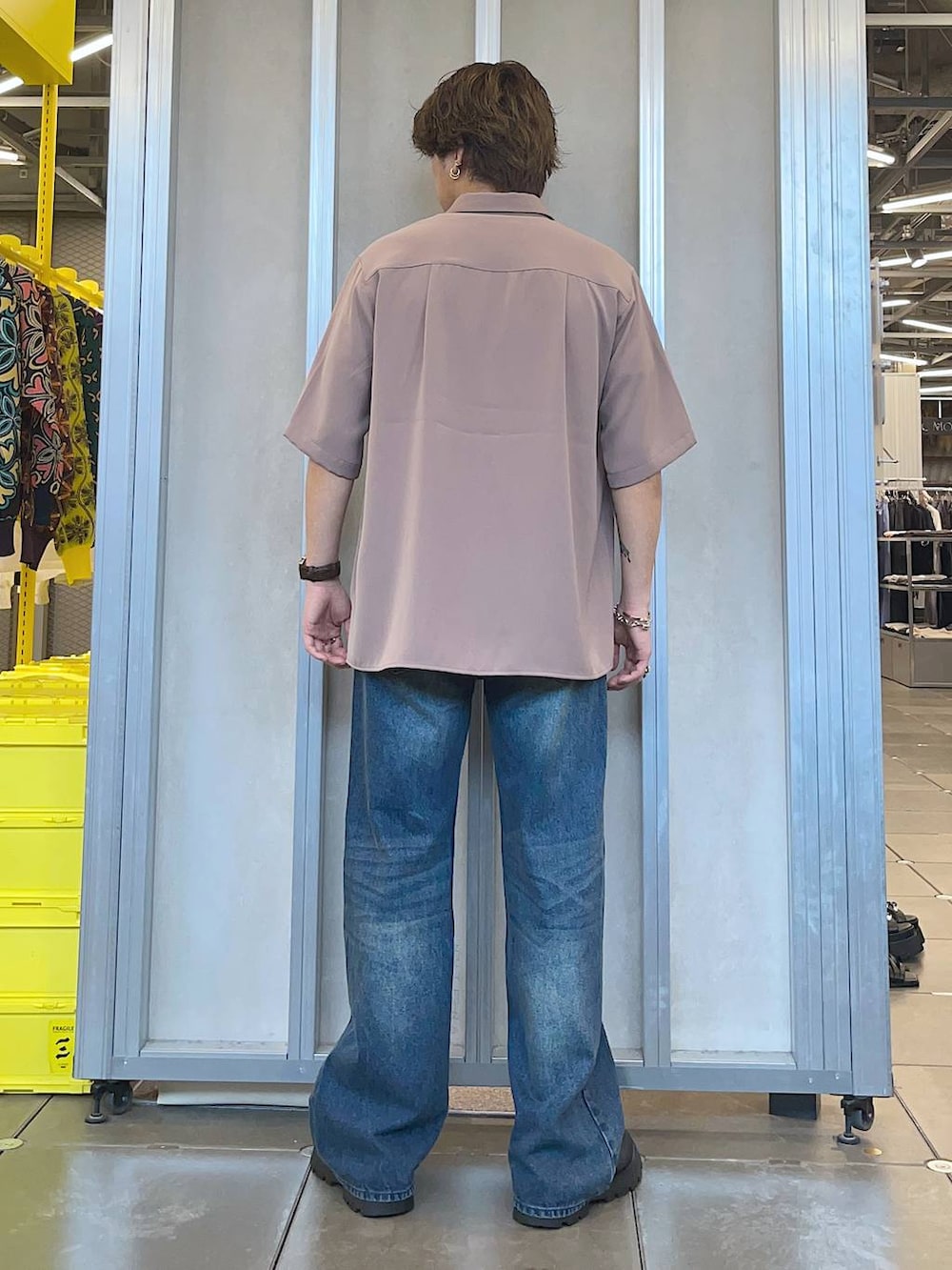 ブラック系のドレスシューズ、ピンク系のシャツ/ブラウス、ブルー系のデニムパンツを着用したメンズの春コーディネートの2枚目の写真