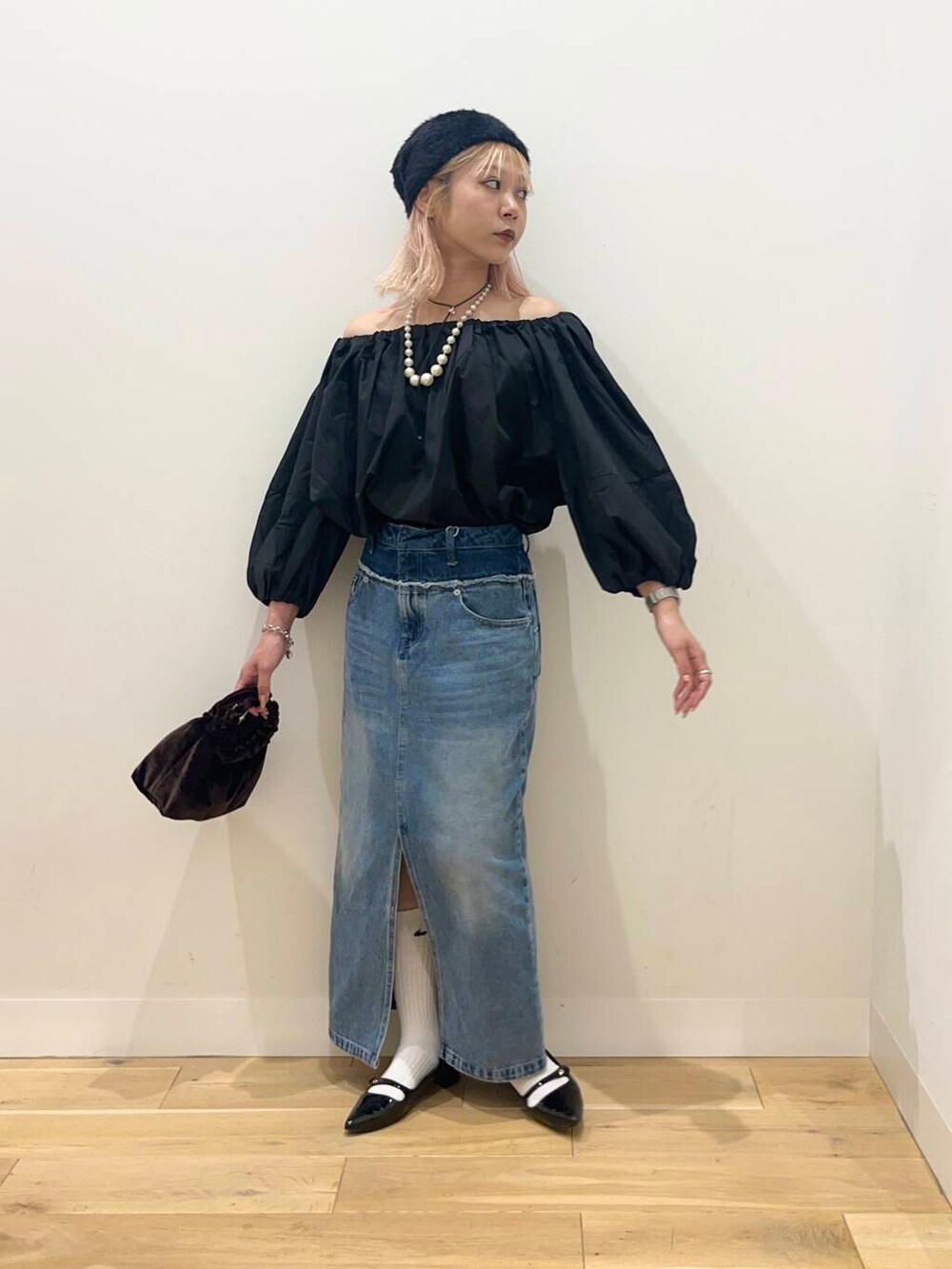 ブラック系のパンプス、ブラック系のシャツ/ブラウス、ブラウン系のハンドバッグを着用したレディースの夏コーディネートの2枚目の写真