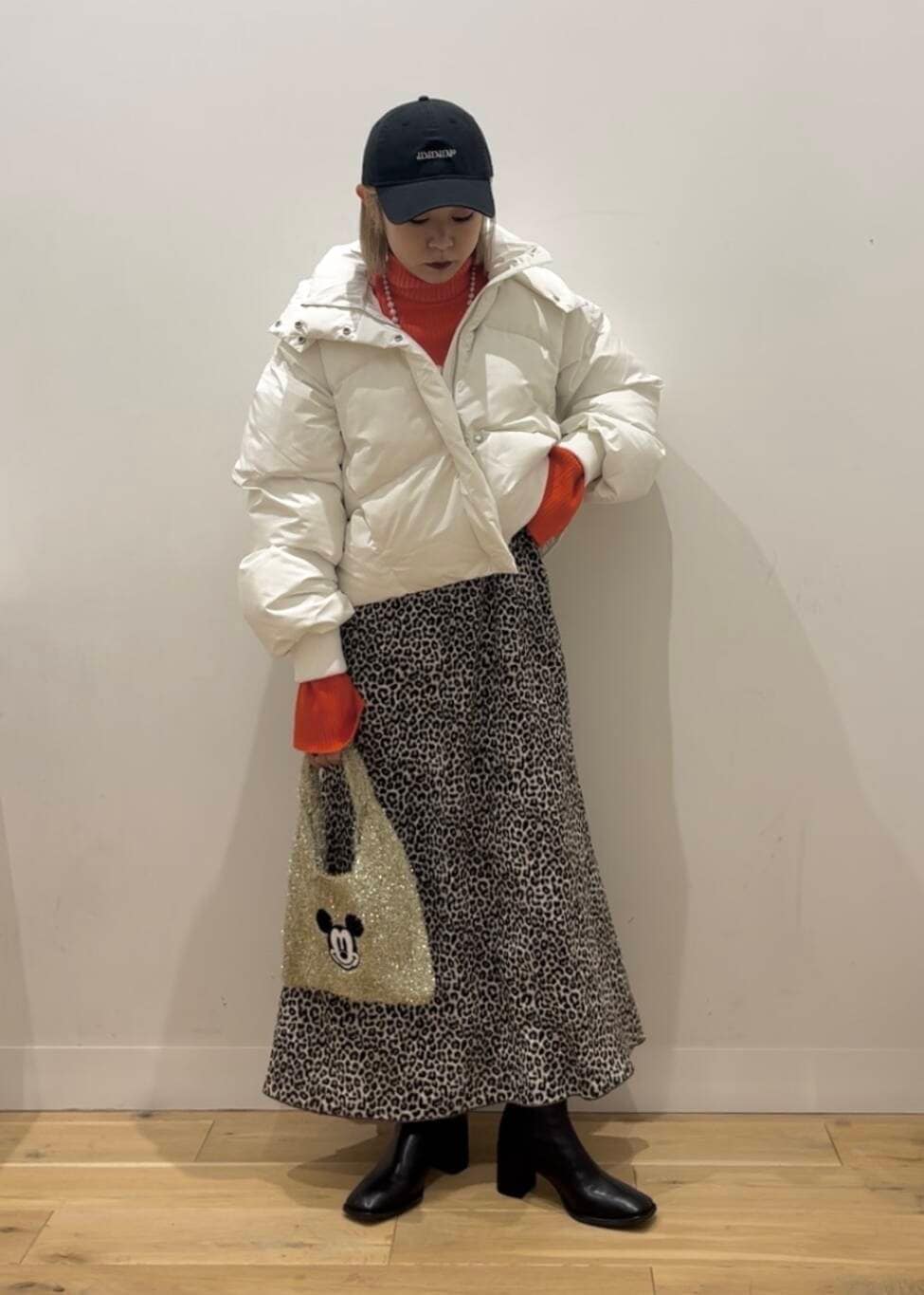 ホワイト系のダウンジャケット/コート、ブラック系のブーツ、ゴールド系のトートバッグを着用したレディースの秋コーディネートの3枚目の写真