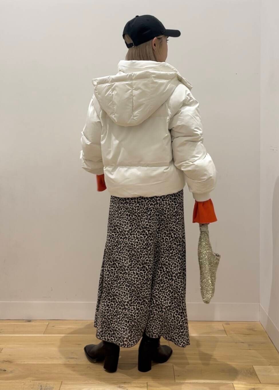 ホワイト系のダウンジャケット/コート、ブラック系のブーツ、ゴールド系のトートバッグを着用したレディースの秋コーディネートの4枚目の写真