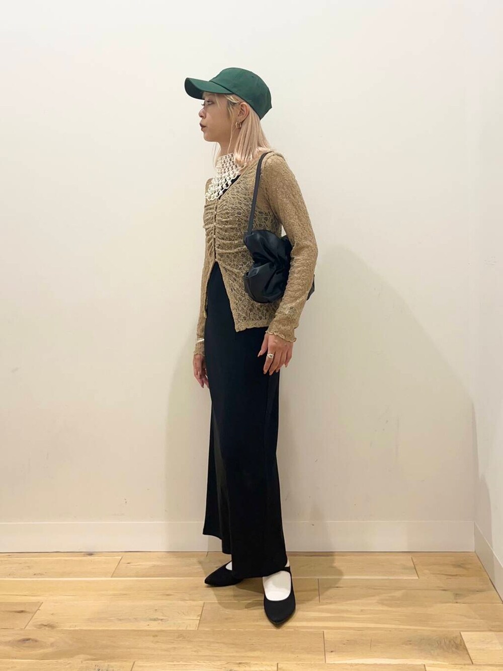 ブラック系のワンピース、ブラック系のハンドバッグ、ブラック系のパンプスを着用したレディースの夏コーディネートの2枚目の写真