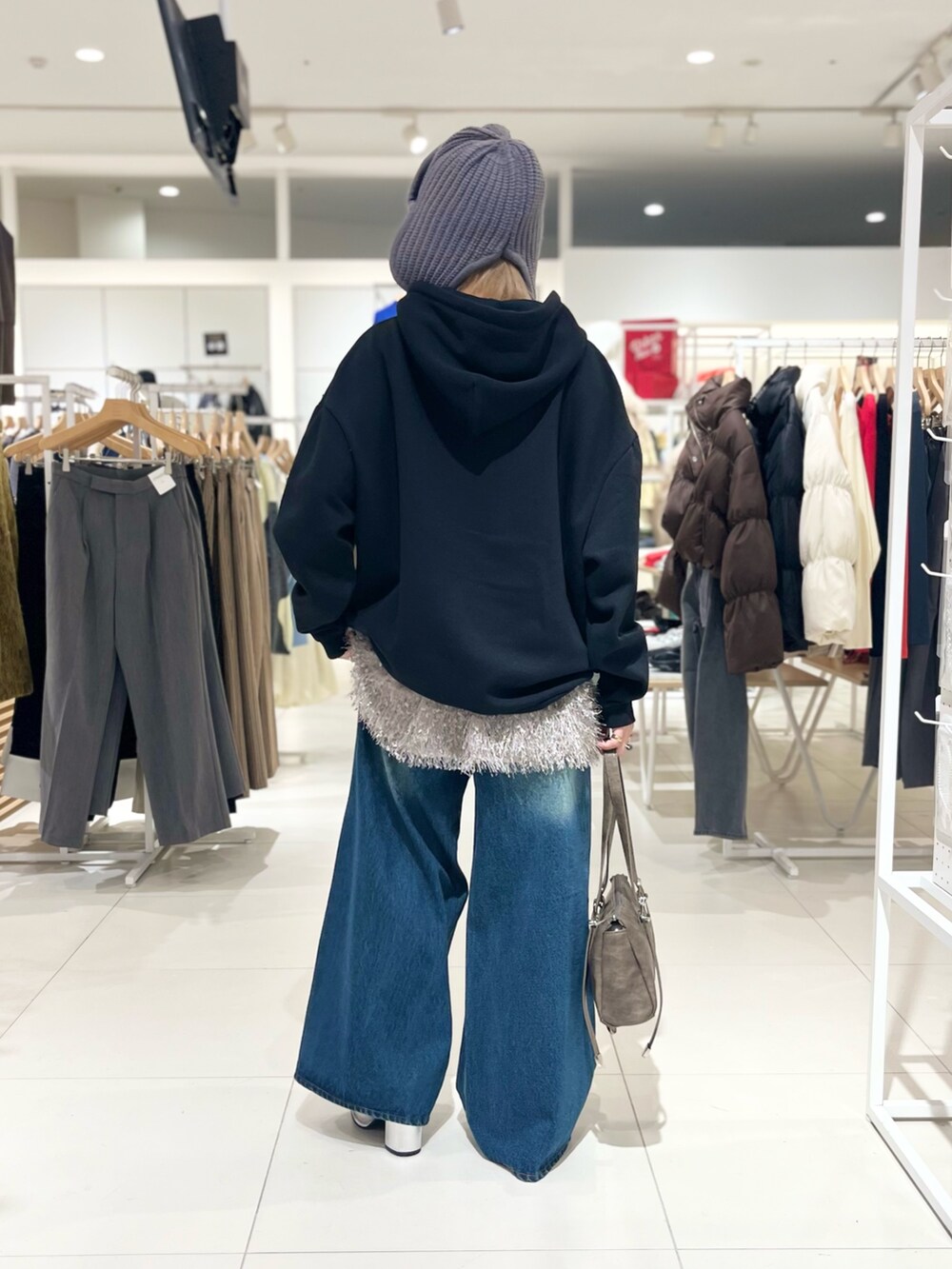 ブラック系のスウェット、グレー系のその他トップス、ブルー系のデニムパンツを着用したレディースの冬コーディネートの3枚目の写真