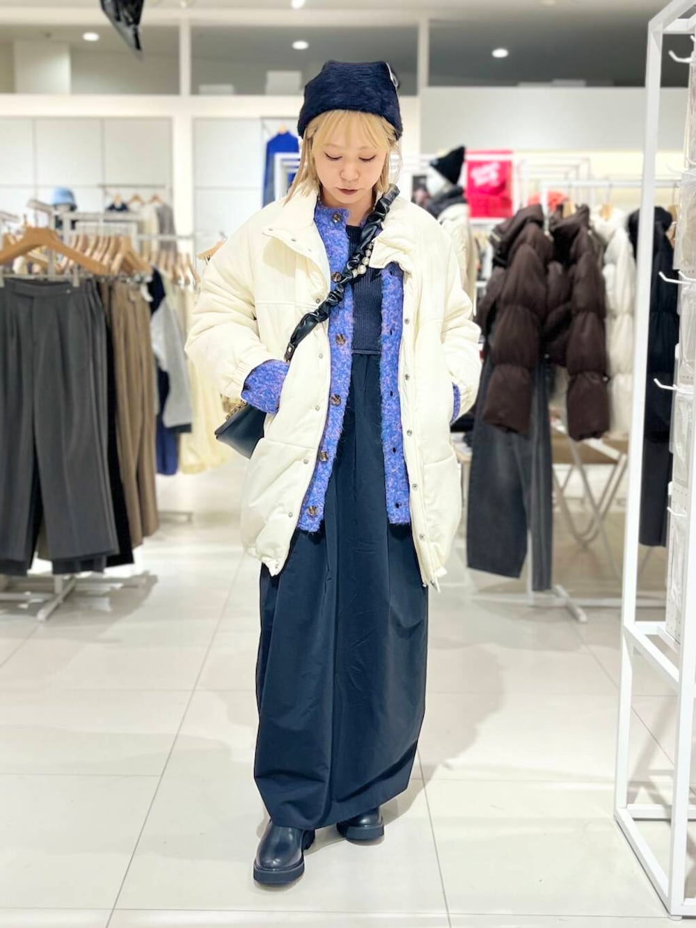 ブラック系のブーツ、ブラック系のショルダーバッグ、ブラック系のワンピースを着用したレディースの冬コーディネートの2枚目の写真