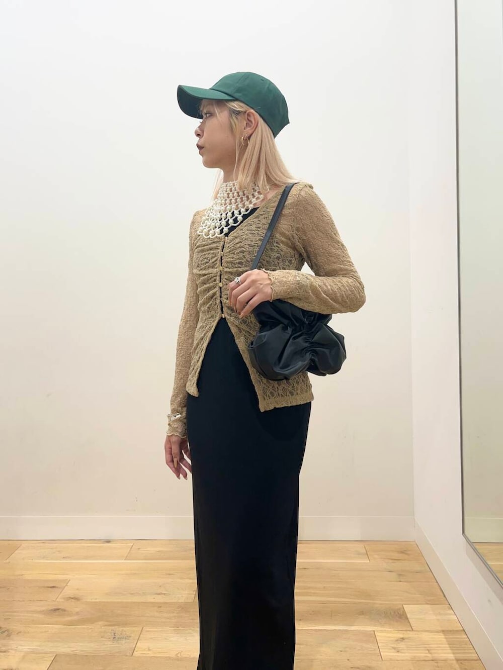 ブラック系のワンピース、ブラック系のハンドバッグ、ブラック系のパンプスを着用したレディースの夏コーディネートの4枚目の写真