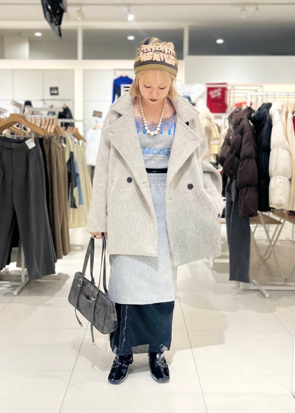 ブラック系のブーツ、ブラック系のスカート、グレー系のボストンバッグを着用したレディースの秋コーディネートの3枚目の写真