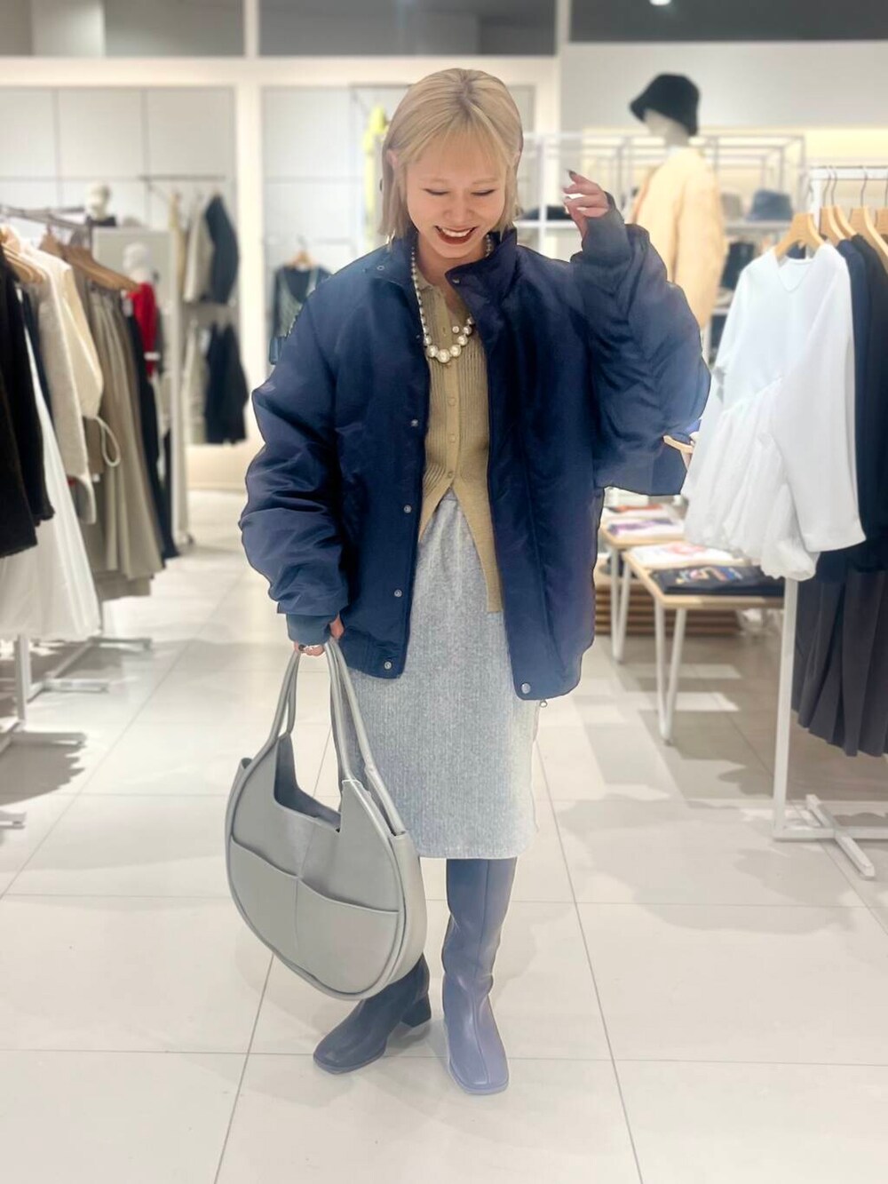 ブラウン系のブーツ、シルバー系のハンドバッグ、ベージュ系のカーディガン/ボレロを着用したレディースの秋コーディネートの3枚目の写真