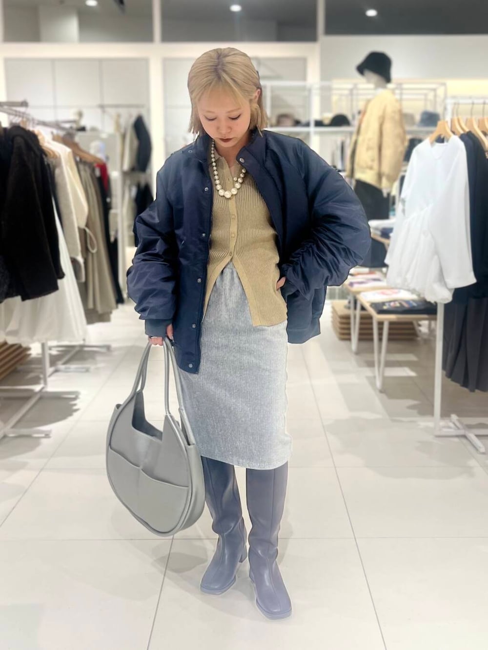 ブラウン系のブーツ、シルバー系のハンドバッグ、ベージュ系のカーディガン/ボレロを着用したレディースの秋コーディネートの2枚目の写真