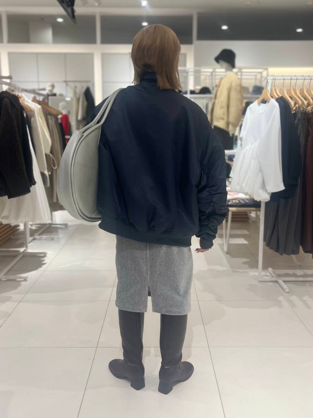 ブラウン系のブーツ、シルバー系のハンドバッグ、ベージュ系のカーディガン/ボレロを着用したレディースの秋コーディネートの4枚目の写真