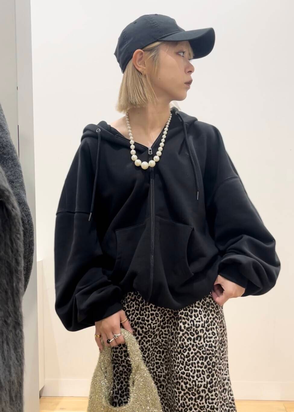 ブラック系のブーツ、ゴールド系のトートバッグ、ブラウン系のスカートを着用したレディースの秋コーディネートの4枚目の写真