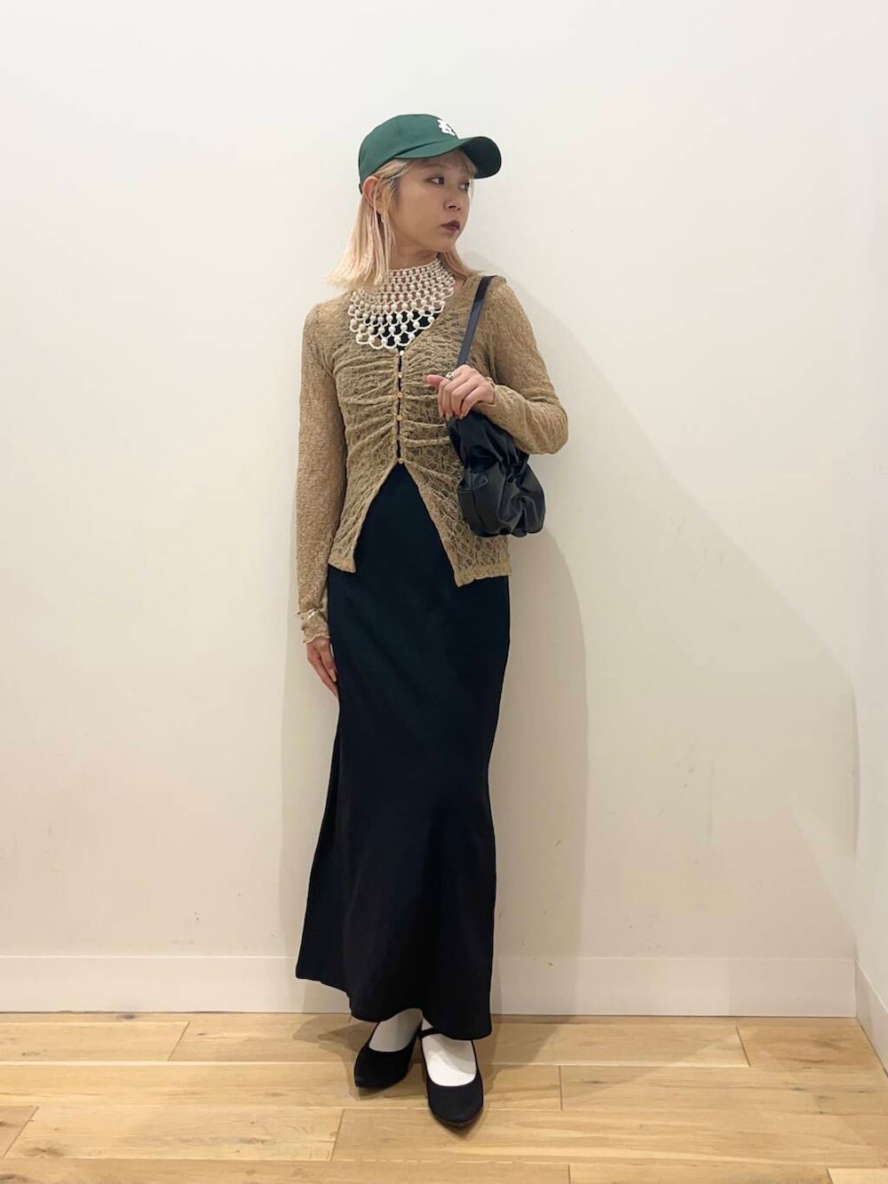 ブラック系のワンピース、ブラック系のハンドバッグ、ブラック系のパンプスを着用したレディースの夏コーディネートの3枚目の写真