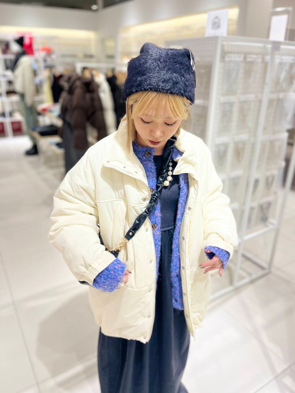 ブラック系のブーツ、ブラック系のショルダーバッグ、ブラック系のワンピースを着用したレディースの冬コーディネートの5枚目の写真