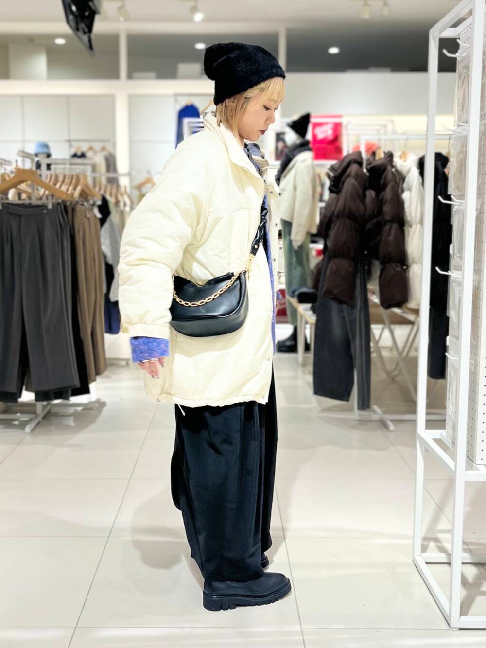 ブラック系のブーツ、ブラック系のショルダーバッグ、ブラック系のワンピースを着用したレディースの冬コーディネートの4枚目の写真