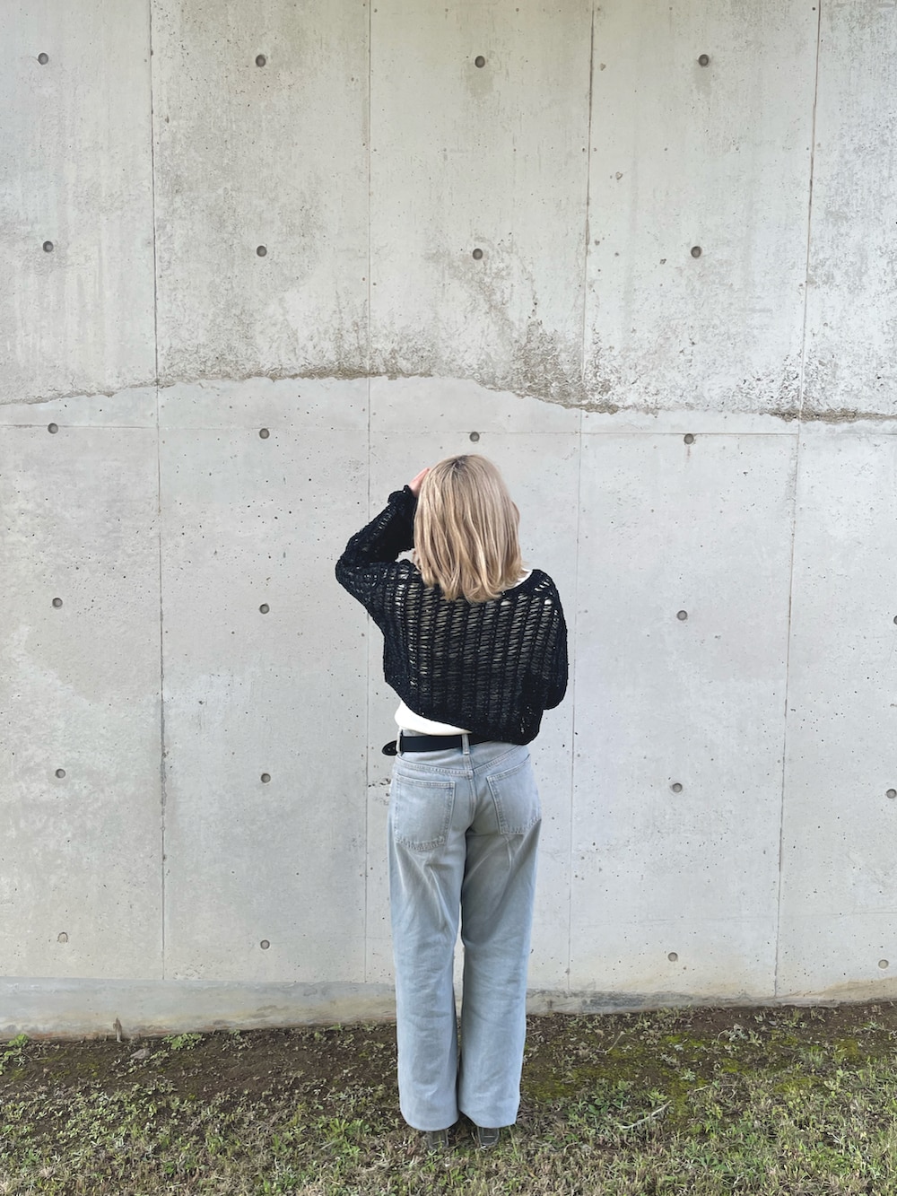 ブラック系のカーディガン/ボレロ、ホワイト系のニット/セーター、ブルー系のデニムパンツを着用したレディースの春コーディネートの2枚目の写真