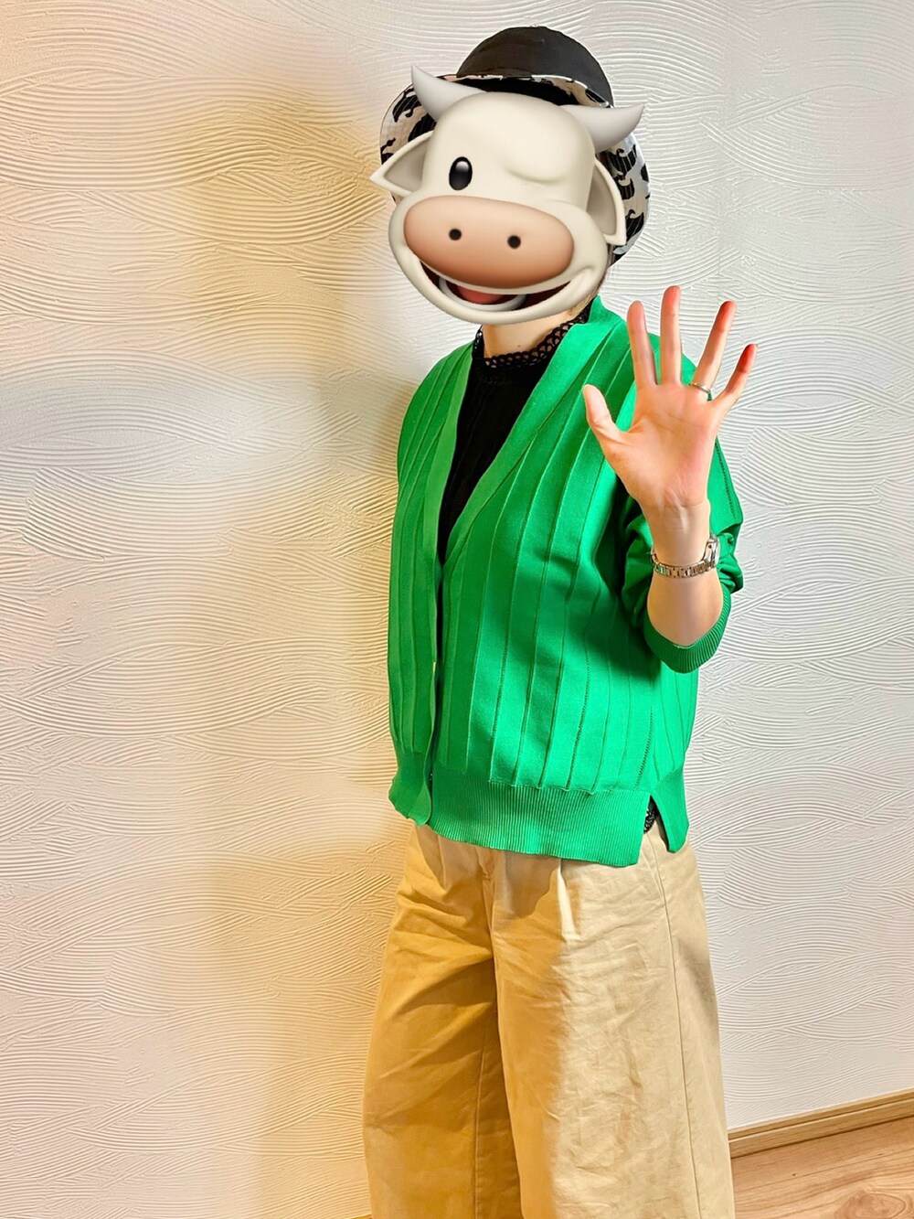 グリーン系のカーディガン/ボレロ、ベージュ系のチノパンツ、ブラック系のハットを着用したレディースの春コーディネートの3枚目の写真