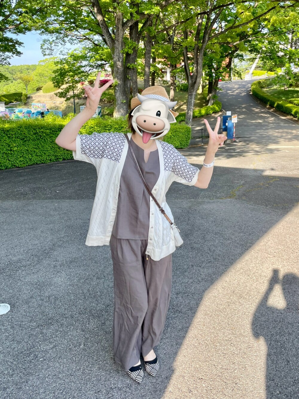 グレー系のパンツ、グレー系のトップス、ホワイト系のカーディガン/ボレロを着用したレディースの春コーディネートの3枚目の写真