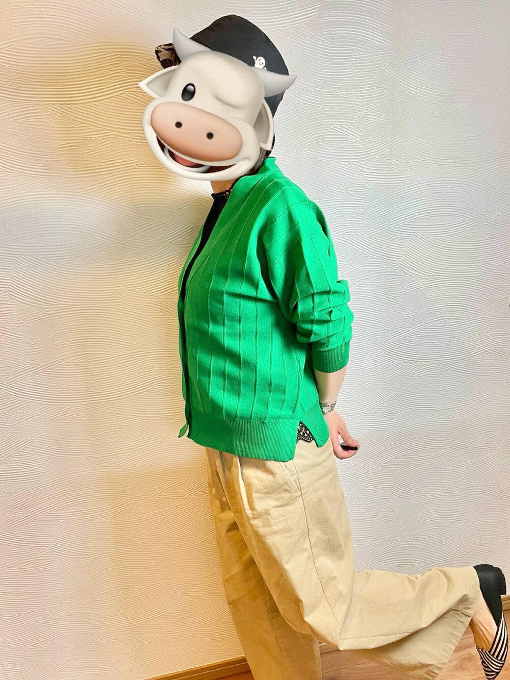 グリーン系のカーディガン/ボレロ、ベージュ系のチノパンツ、ブラック系のハットを着用したレディースの春コーディネートの4枚目の写真