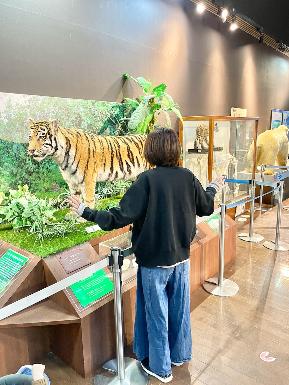 ブラック系のカーディガン/ボレロ、ブルー系のデニムパンツを着用したレディースの春コーディネートの4枚目の写真