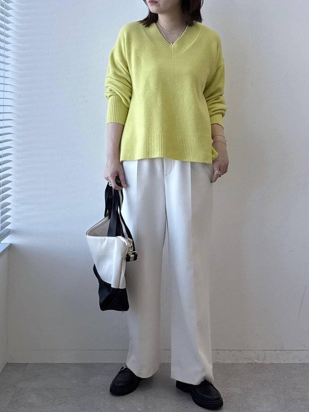 ベージュ系のトートバッグ、ホワイト系のその他パンツ、イエロー系のニット/セーターを着用したレディースの冬コーディネートの3枚目の写真