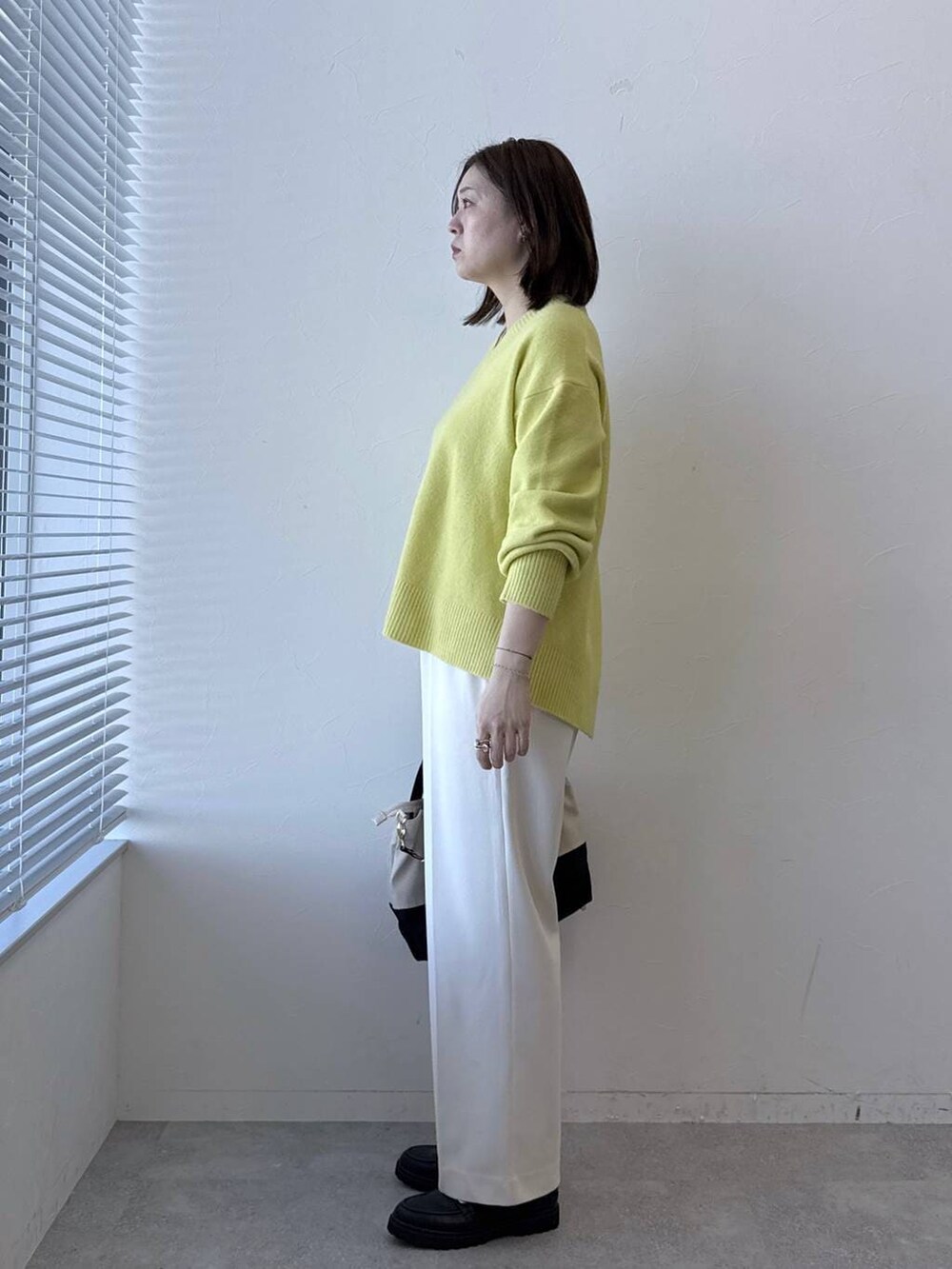 ベージュ系のトートバッグ、ホワイト系のその他パンツ、イエロー系のニット/セーターを着用したレディースの冬コーディネートの4枚目の写真