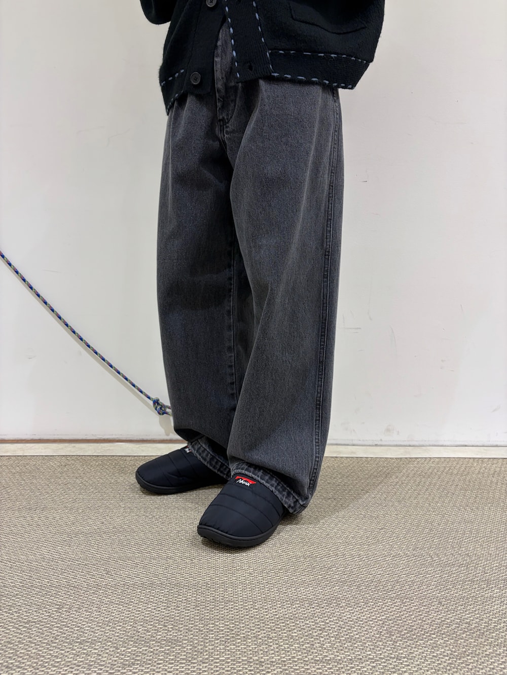 ブラック系のカーディガン/ボレロ、グレー系のデニムパンツ、ブラック系のサンダルを着用したメンズの秋コーディネートの4枚目の写真