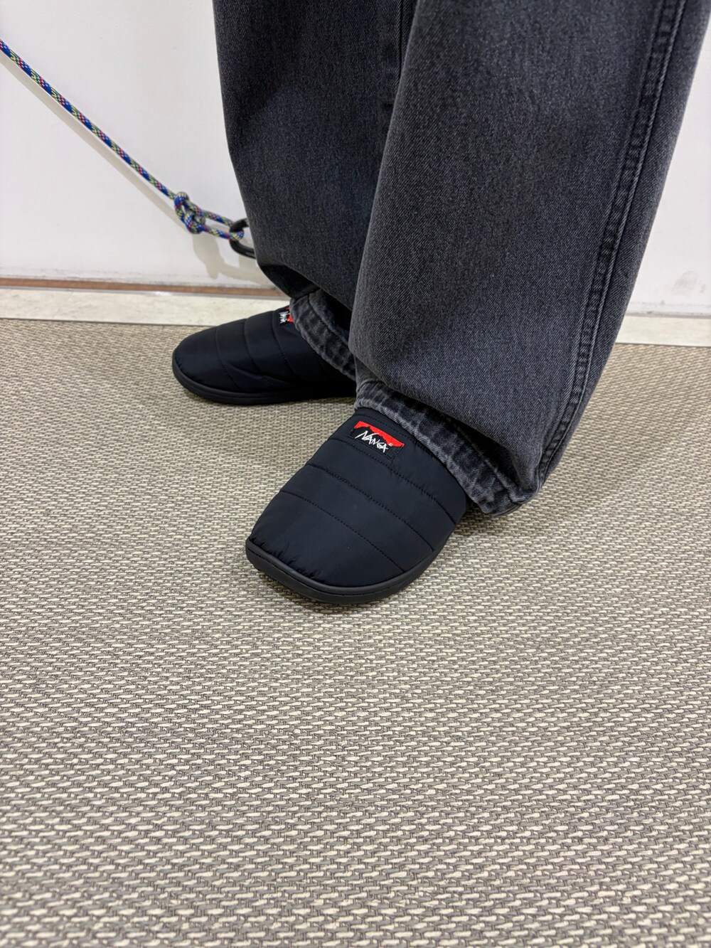 ブラック系のカーディガン/ボレロ、グレー系のデニムパンツ、ブラック系のサンダルを着用したメンズの秋コーディネートの5枚目の写真