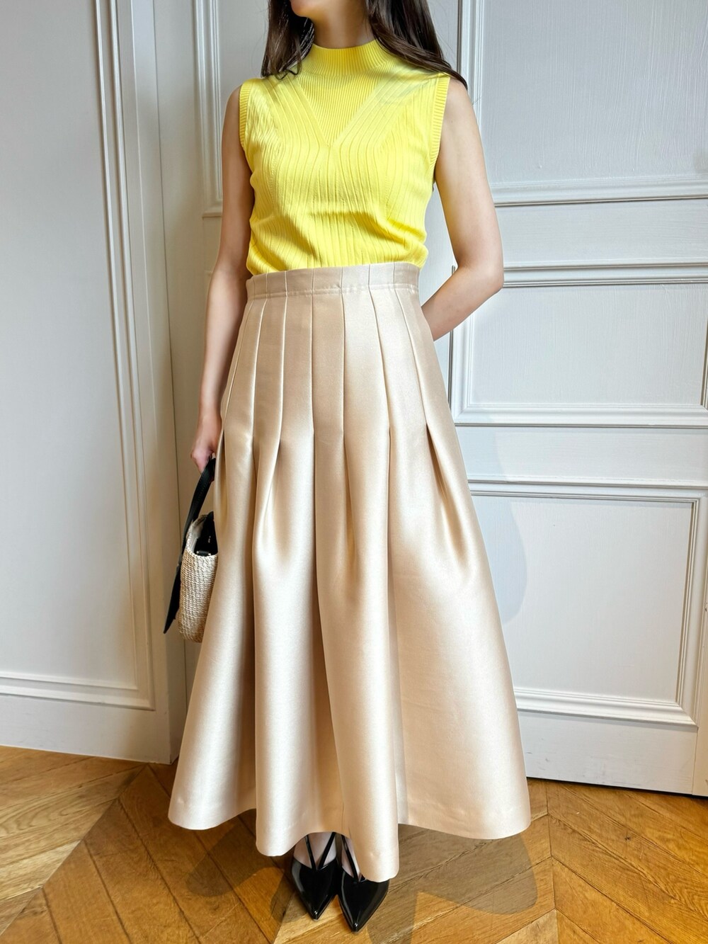 イエロー系のニット/セーター、ベージュ系のスカートを着用したレディースの春コーディネートの4枚目の写真