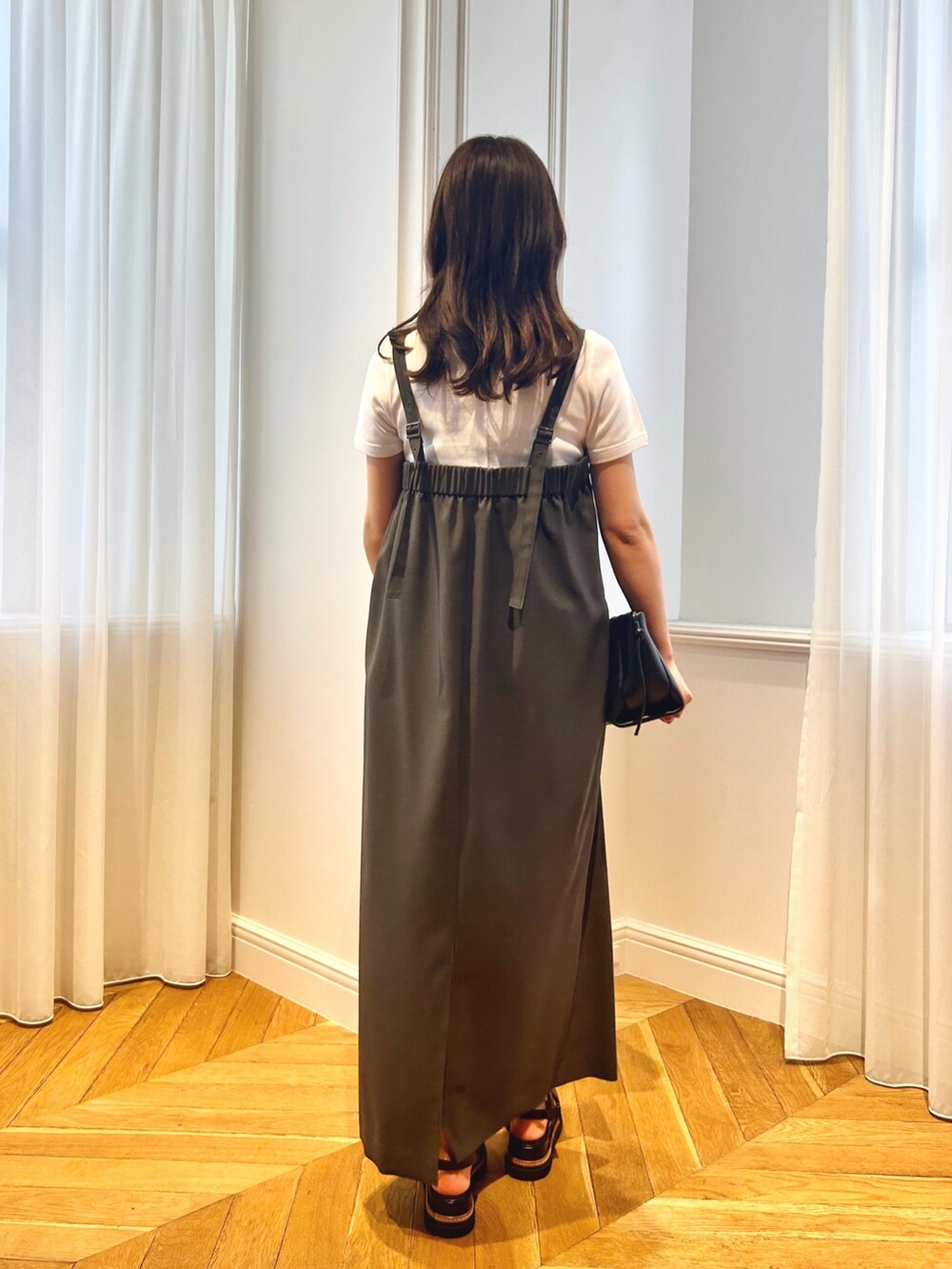 グレー系のワンピース、ホワイト系のTシャツ/カットソーを着用したレディースの春コーディネートの3枚目の写真