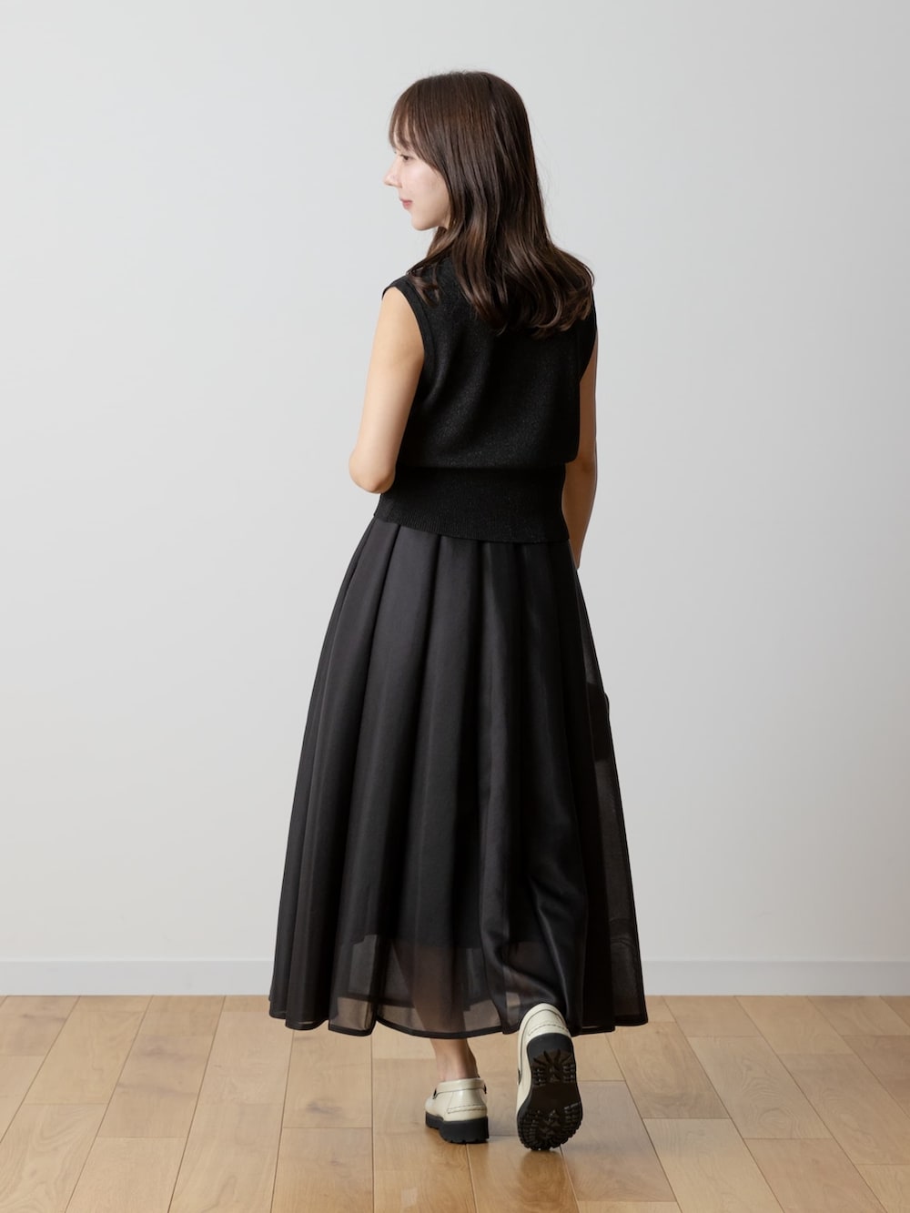 ブラック系のニット/セーター、ブラック系のスカートを着用したレディースの夏コーディネートの4枚目の写真