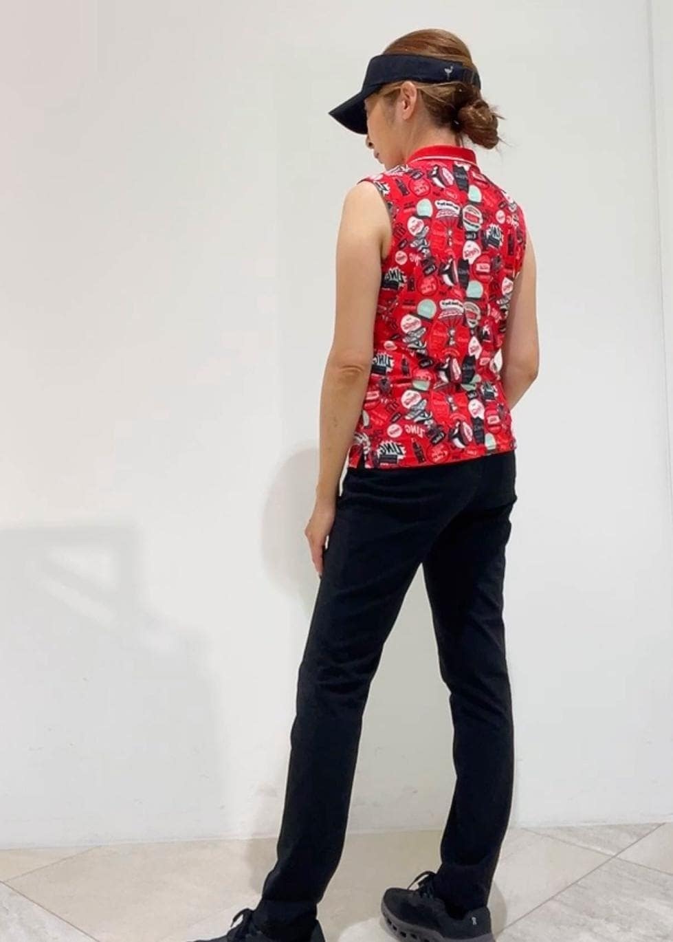 ブラック系のその他パンツ、レッド系のポロシャツ、ブラック系のサンバイザーを着用したレディースの夏コーディネートの2枚目の写真