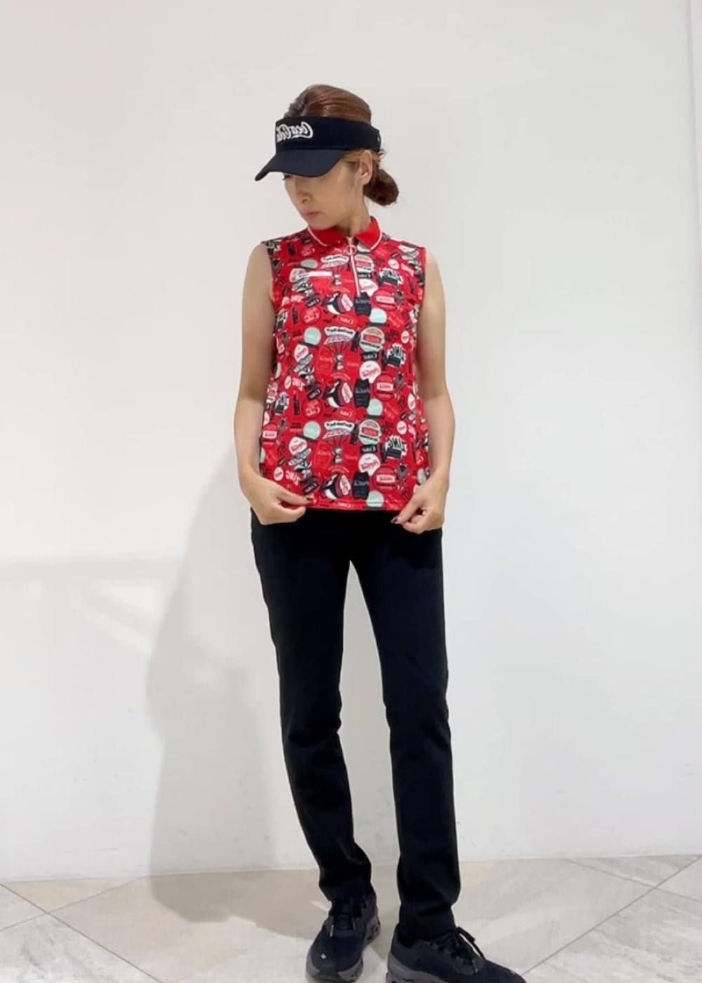 ブラック系のその他パンツ、レッド系のポロシャツ、ブラック系のサンバイザーを着用したレディースの夏コーディネートの4枚目の写真