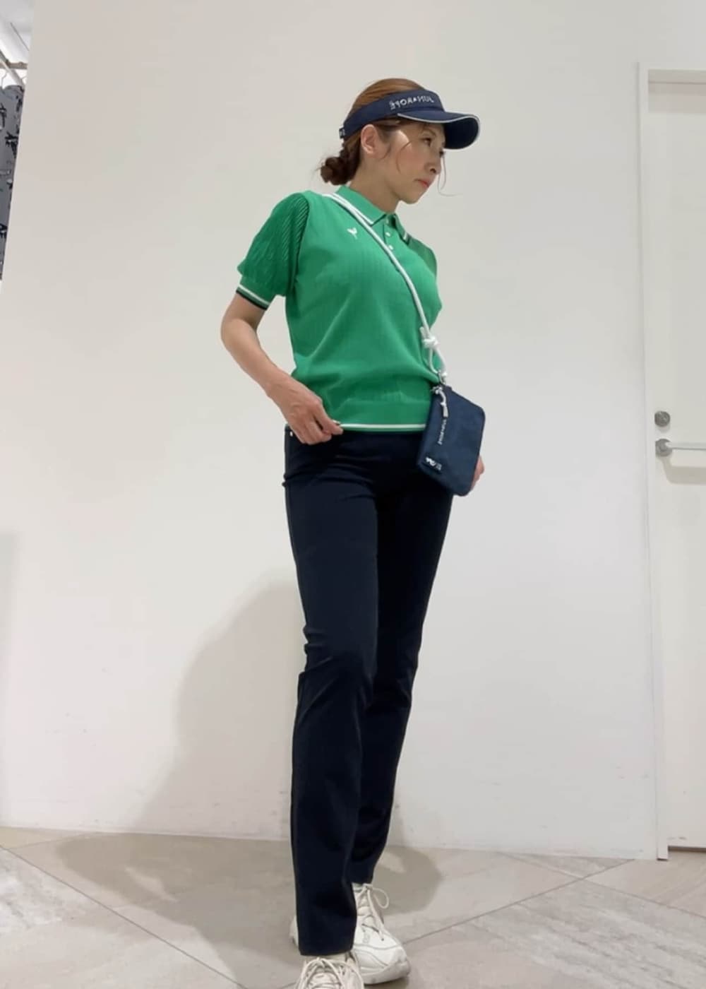 ブルー系のショルダーバッグ、グリーン系のポロシャツ、ブルー系のその他パンツを着用したレディースの春コーディネートの2枚目の写真