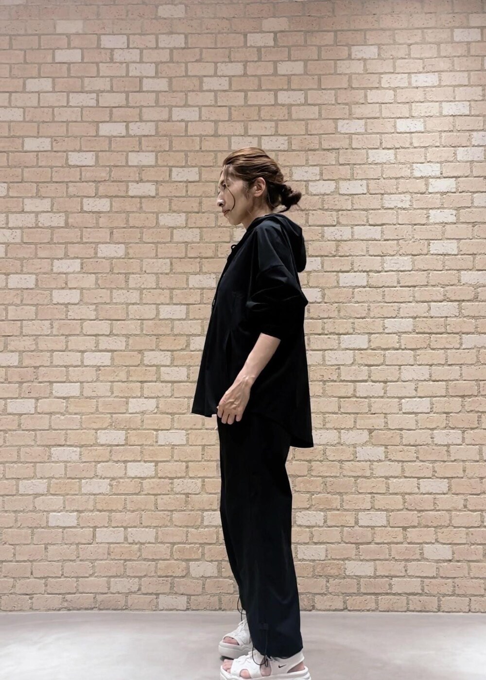 ブラック系のその他パンツ、ホワイト系のタンクトップ、ブラック系のパーカーを着用したレディースの夏コーディネートの3枚目の写真