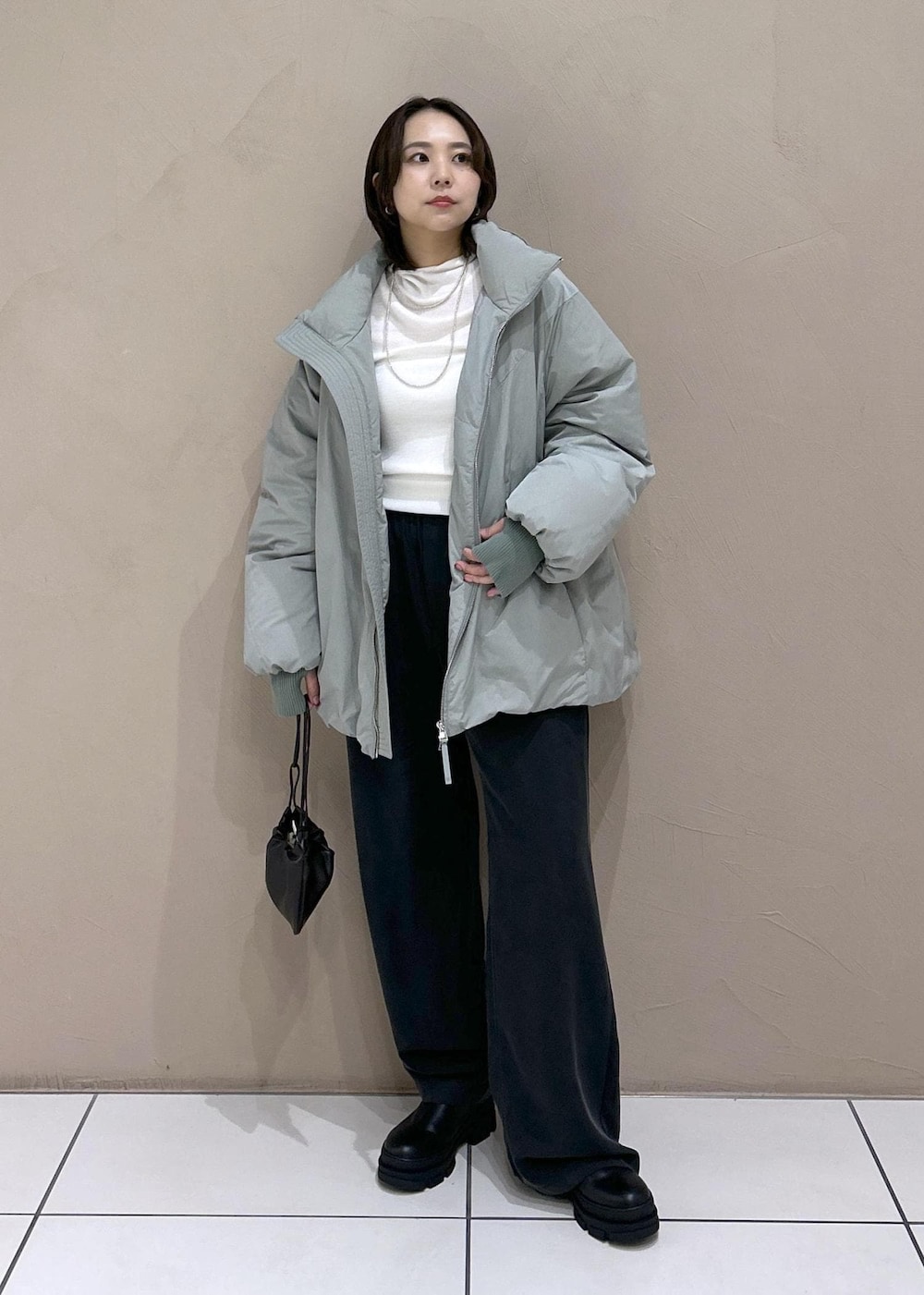 ブラック系のブーツ、ブラック系のその他パンツ、ホワイト系のニット/セーターを着用したレディースの秋コーディネートの2枚目の写真