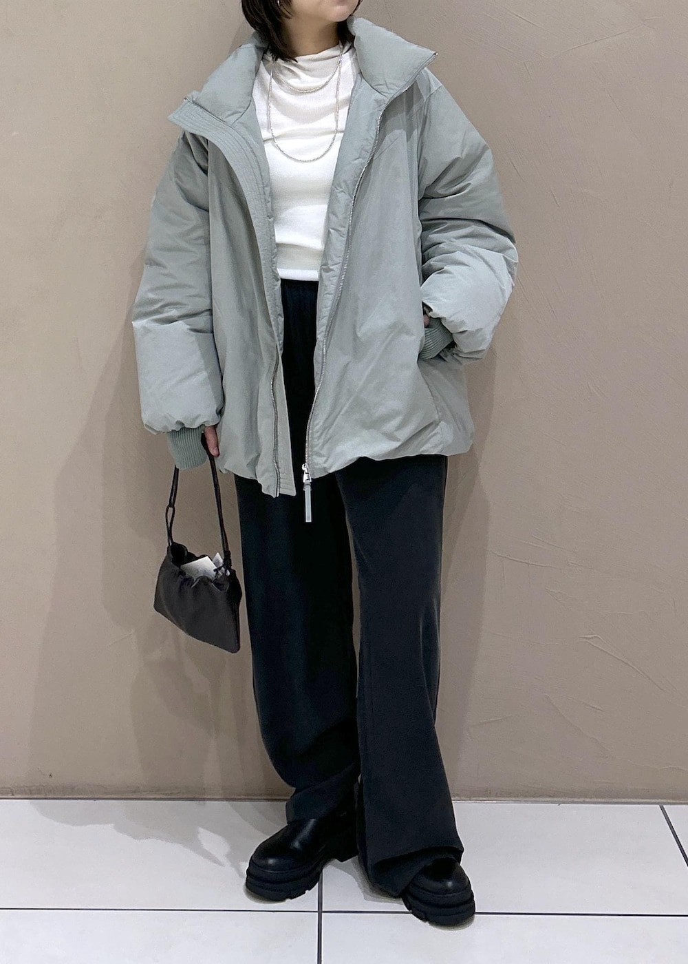 ブラック系のブーツ、ブラック系のその他パンツ、ホワイト系のニット/セーターを着用したレディースの秋コーディネートの3枚目の写真