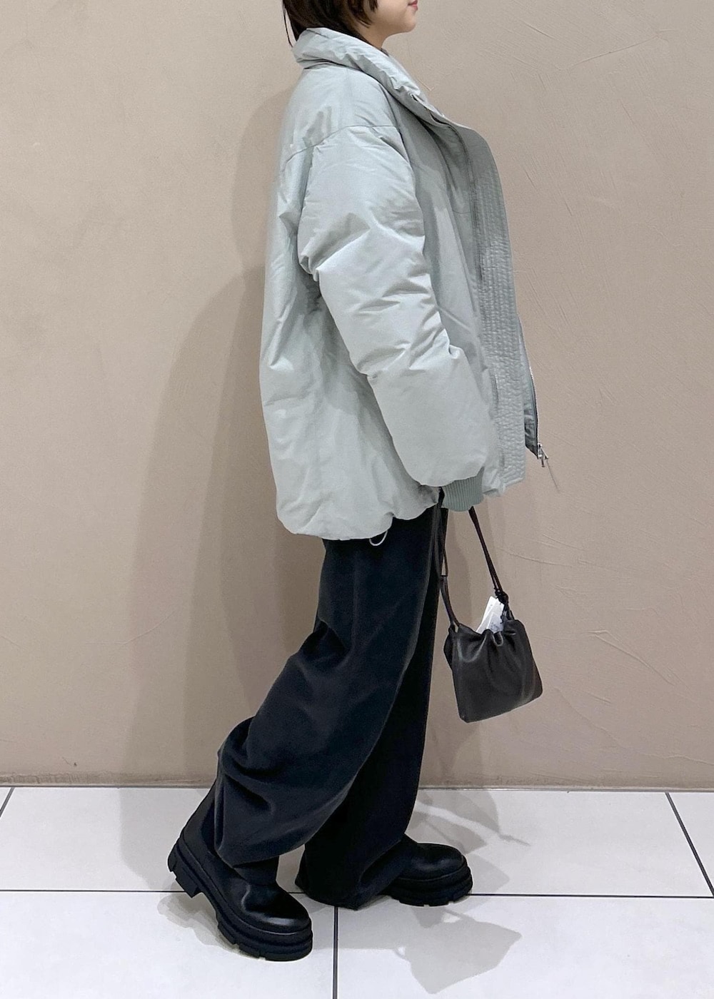 ブラック系のブーツ、ブラック系のその他パンツ、ホワイト系のニット/セーターを着用したレディースの秋コーディネートの4枚目の写真