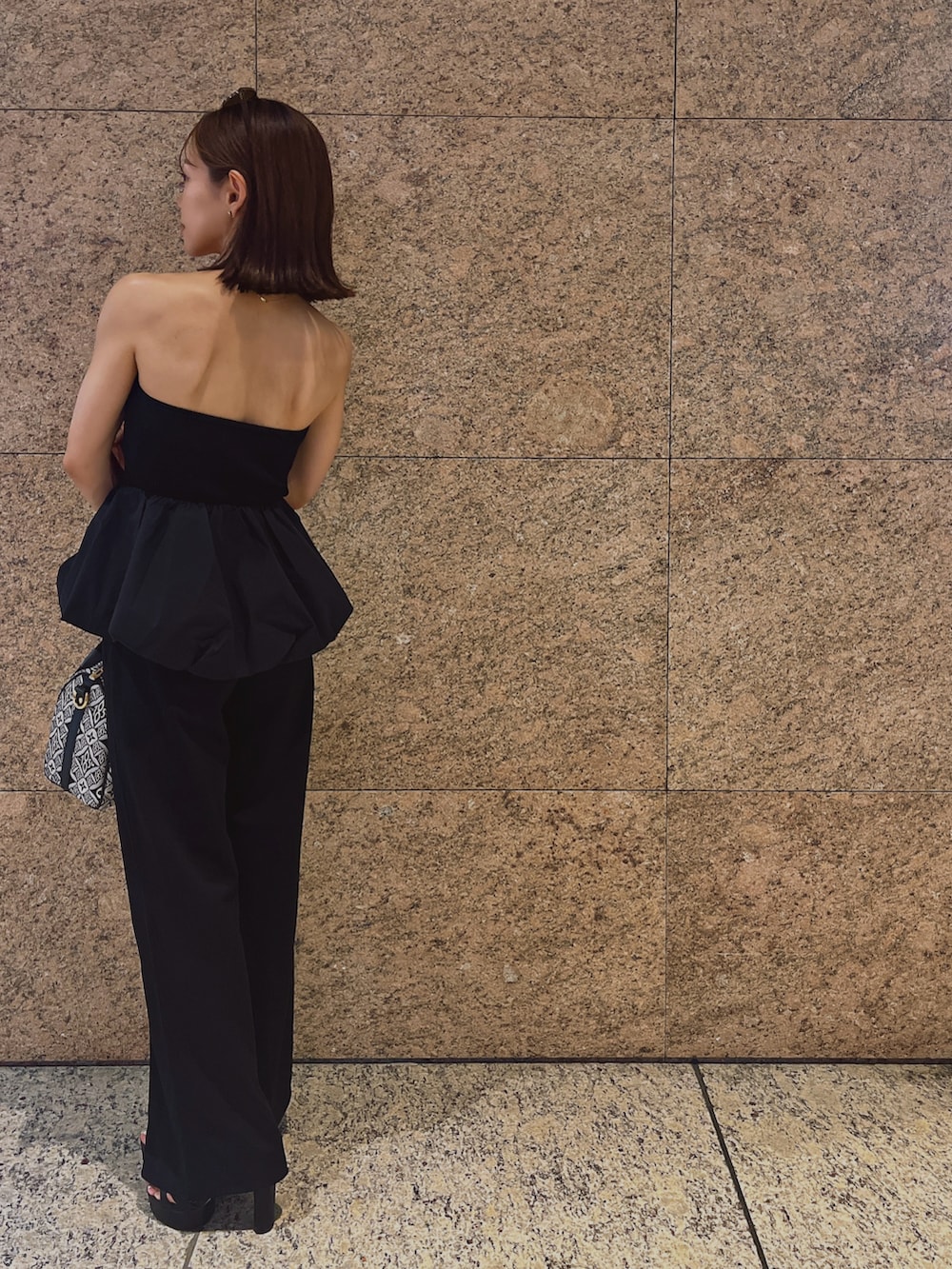 ブラック系のチューブトップ、ブラック系のサンダルを着用したレディースの夏コーディネートの3枚目の写真