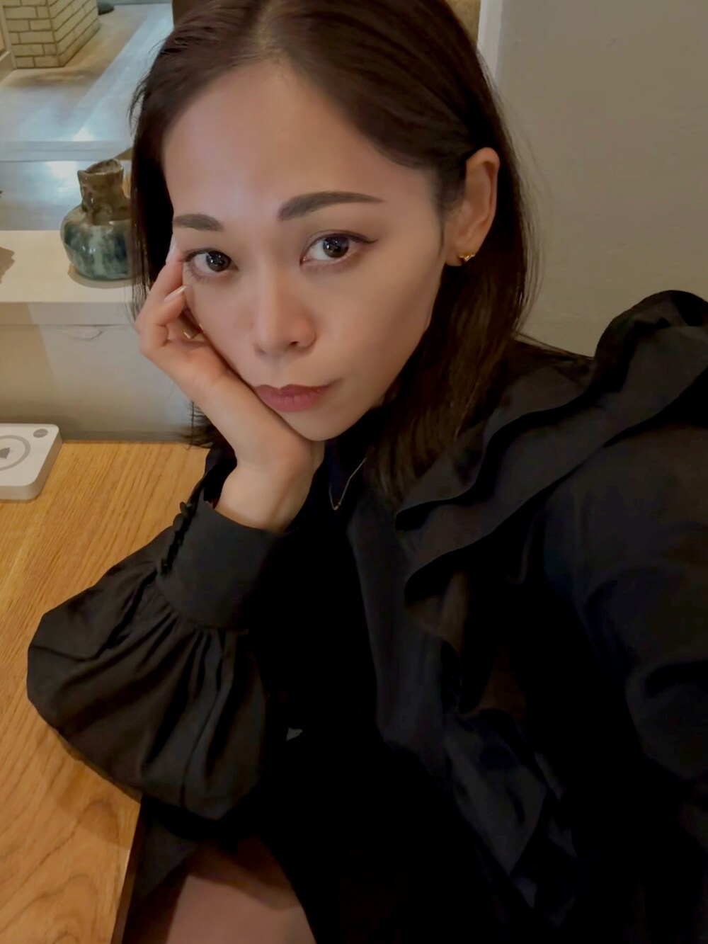 ブラック系のダウンジャケット/コート、ブラック系のハンドバッグ、ブラック系のブーツを着用したレディースの冬コーディネートの3枚目の写真