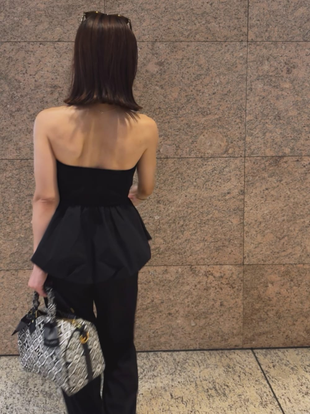 ブラック系のチューブトップ、ブラック系のサンダルを着用したレディースの夏コーディネートの2枚目の写真