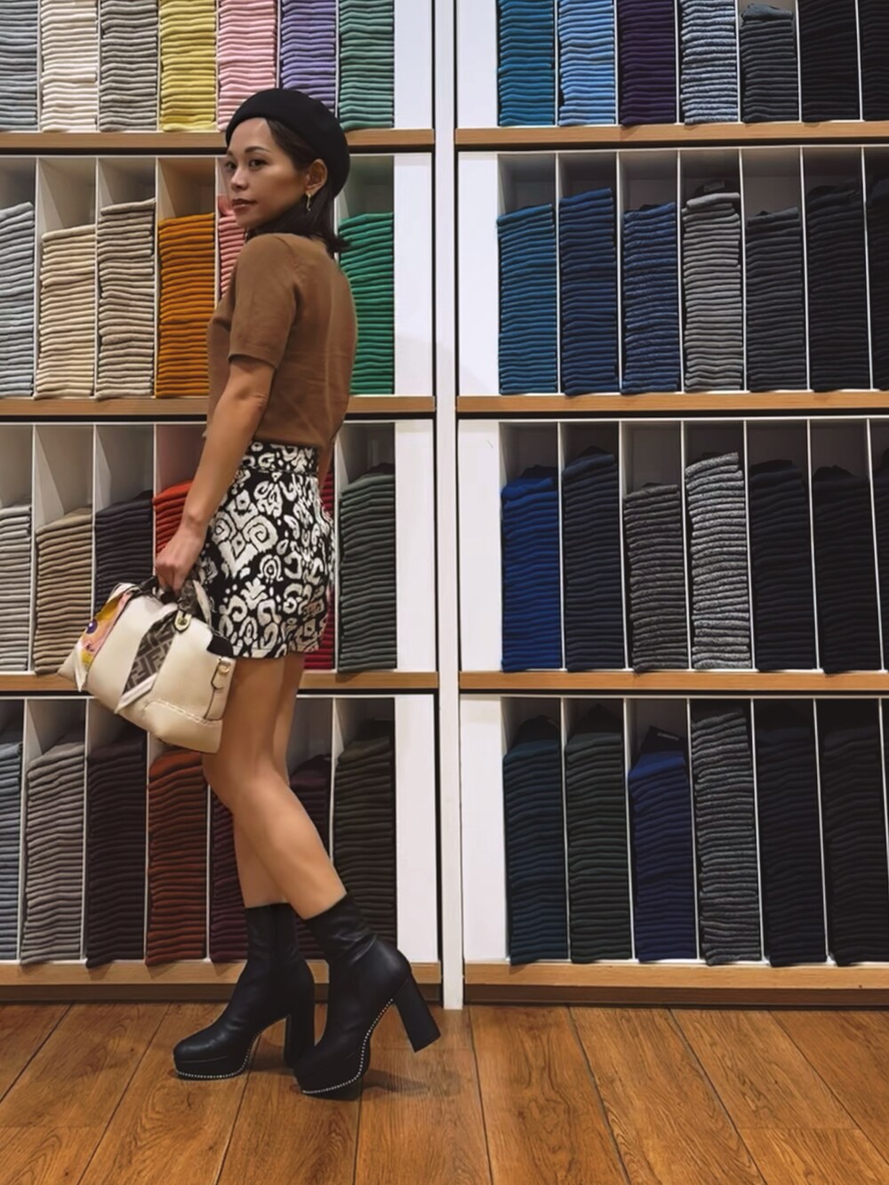 ブラック系のパンツ、ブラウン系のニット/セーター、ホワイト系のバッグを着用したレディースの秋コーディネートの3枚目の写真