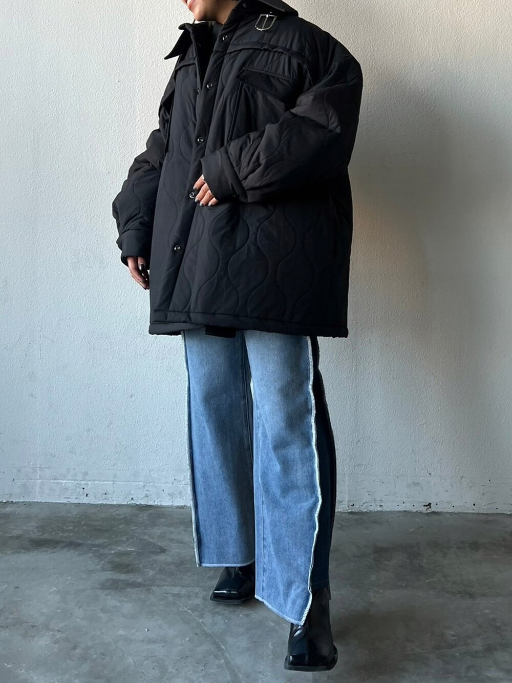 ブラック系のブルゾンを着用したレディースの冬コーディネートの2枚目の写真