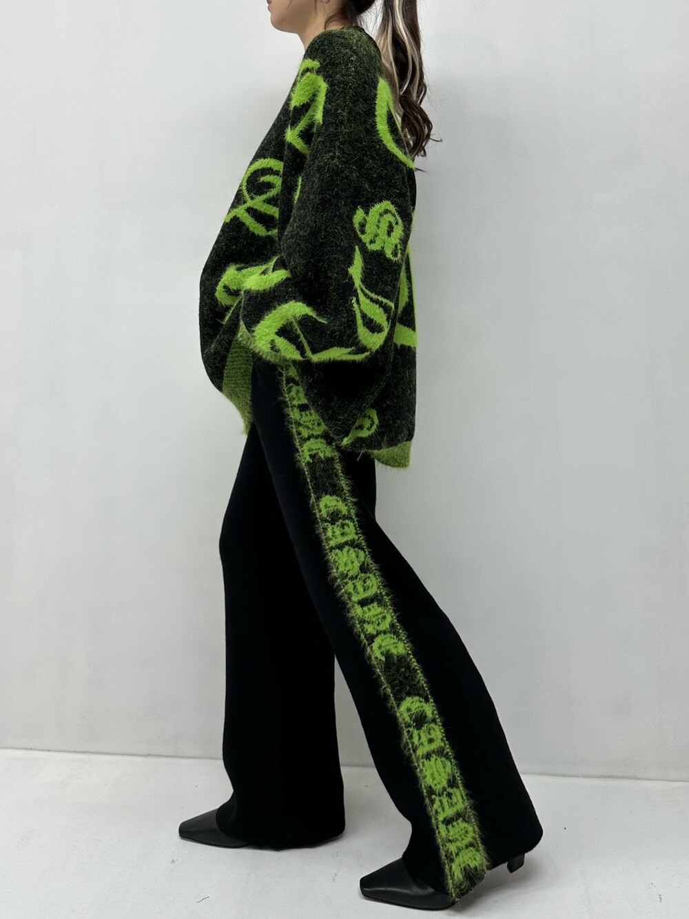 ブラック系のニット/セーター、ブラック系のパンツを着用したレディースの秋コーディネートの2枚目の写真