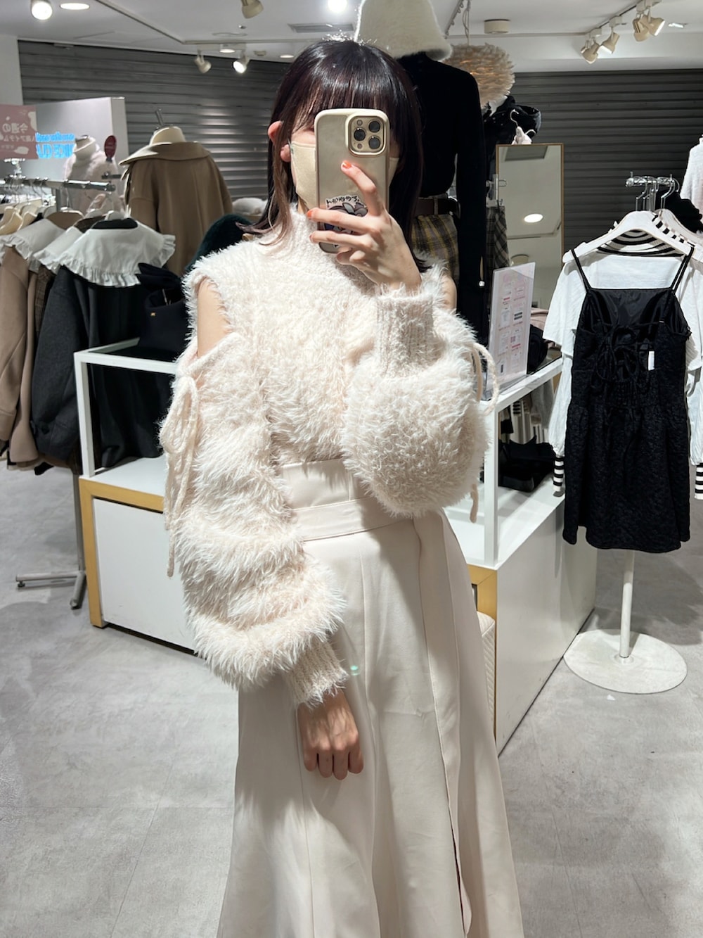 ホワイト系のスカート、ピンク系のニット/セーター、ブラック系のブーツを着用したレディースの冬コーディネートの2枚目の写真